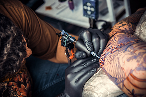 Artist tattooing a customer